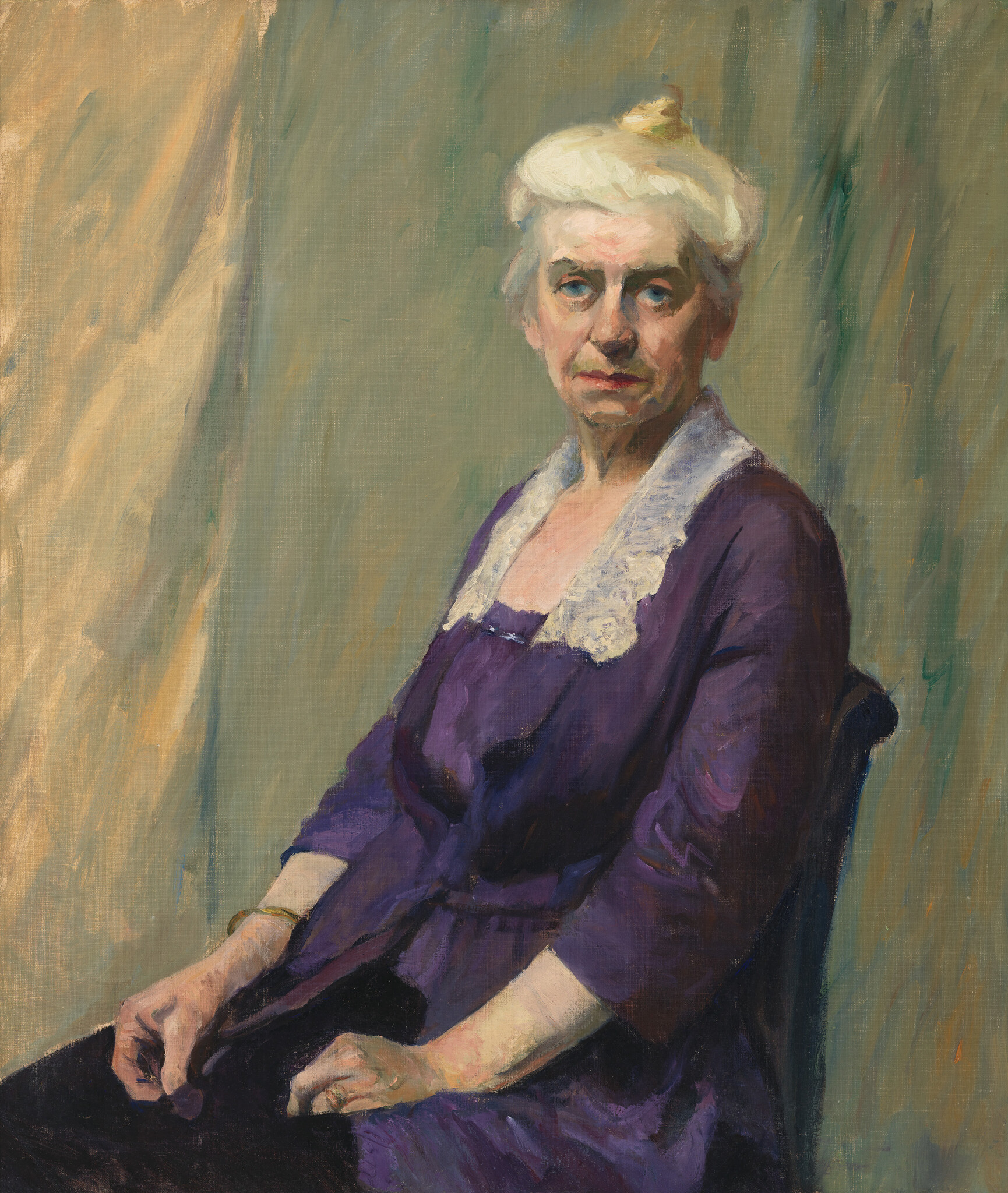 An elderly woman in a purple dress with white lace collar sits with hands folded, gazing forward.