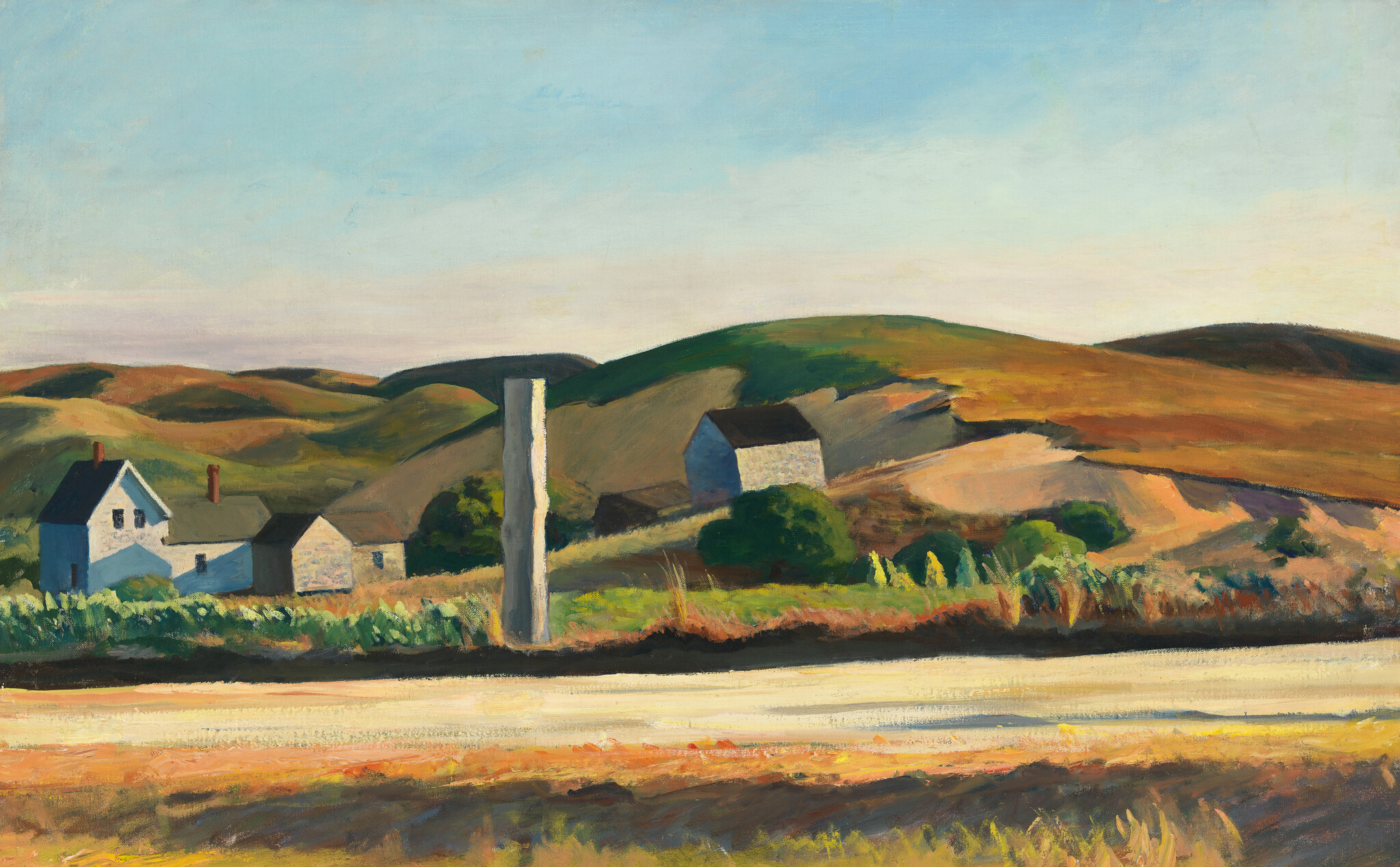 White farmhouses and a tall post sit among rolling sunlit hills beside a light-colored road.