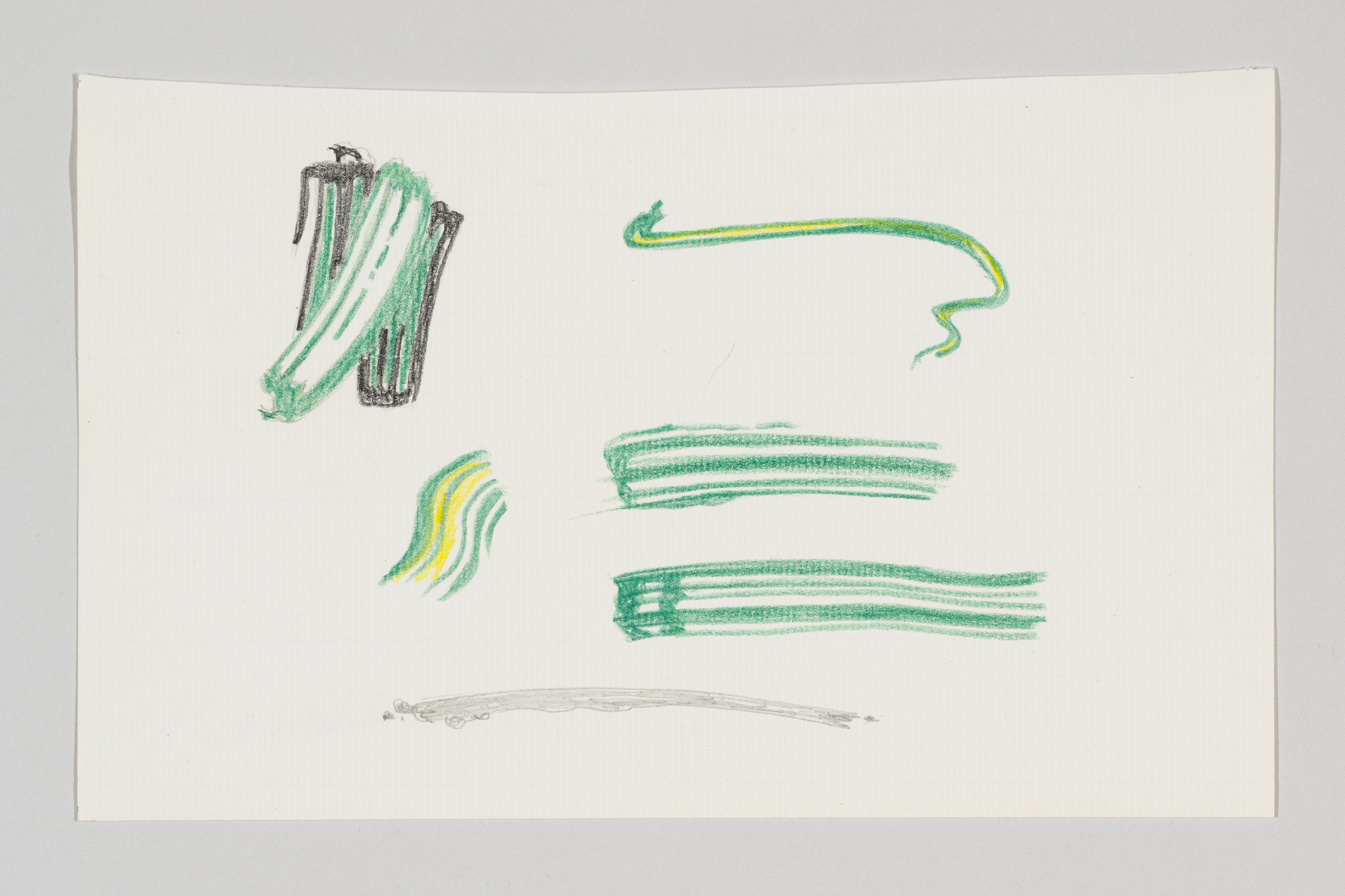 A piece of paper with various crayon scribbles in green and yellow, including what appears to be abstract shapes and lines.