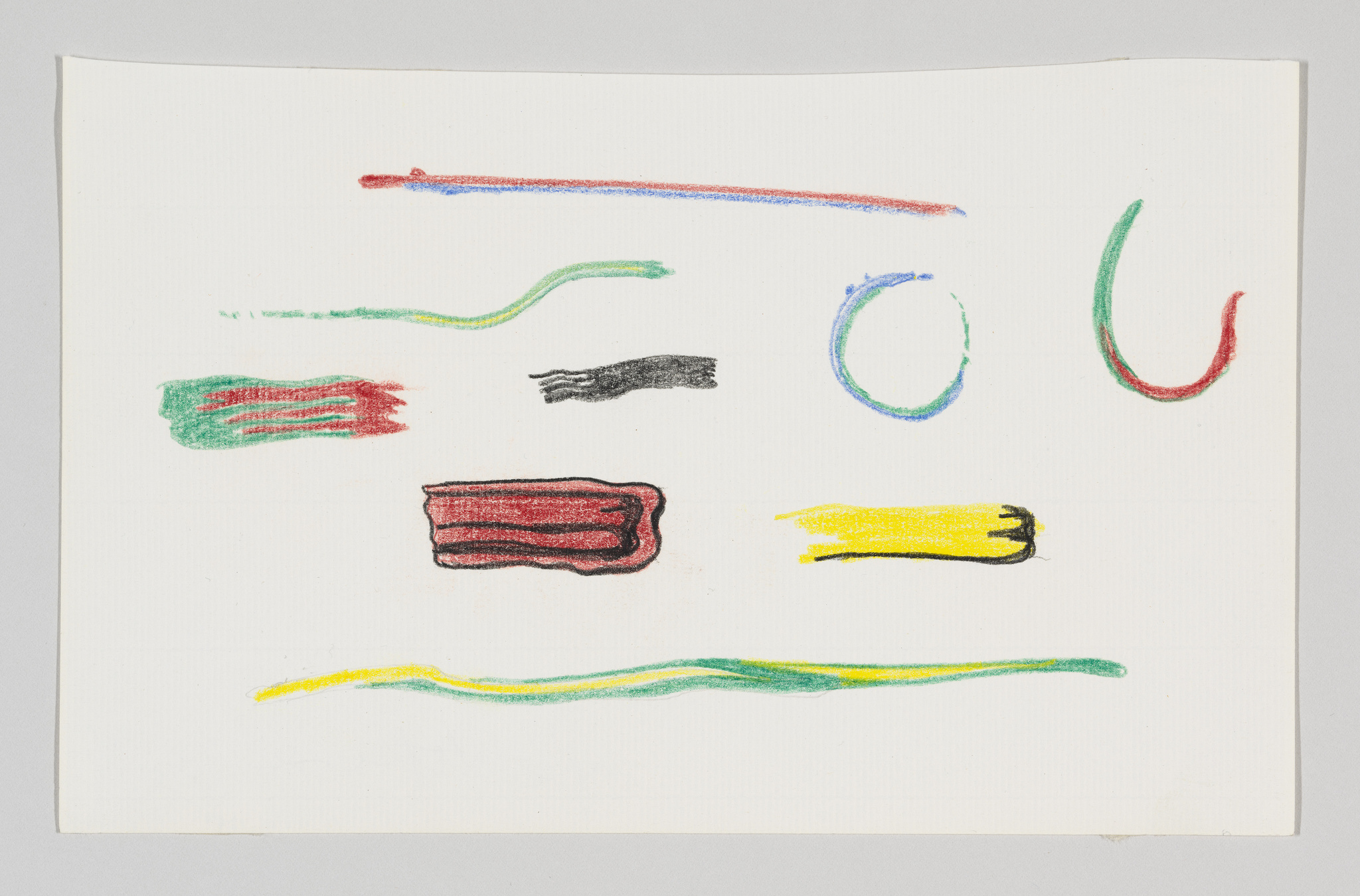 A piece of paper with various crayon scribbles in different colors and shapes, including red, green, blue, yellow, and black lines and squiggles, with no discernible pattern or image.