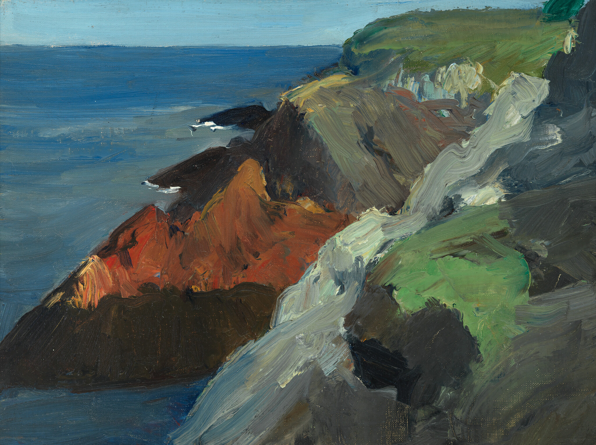 Rugged coastal cliffs with red and green rock faces meeting a calm blue sea.