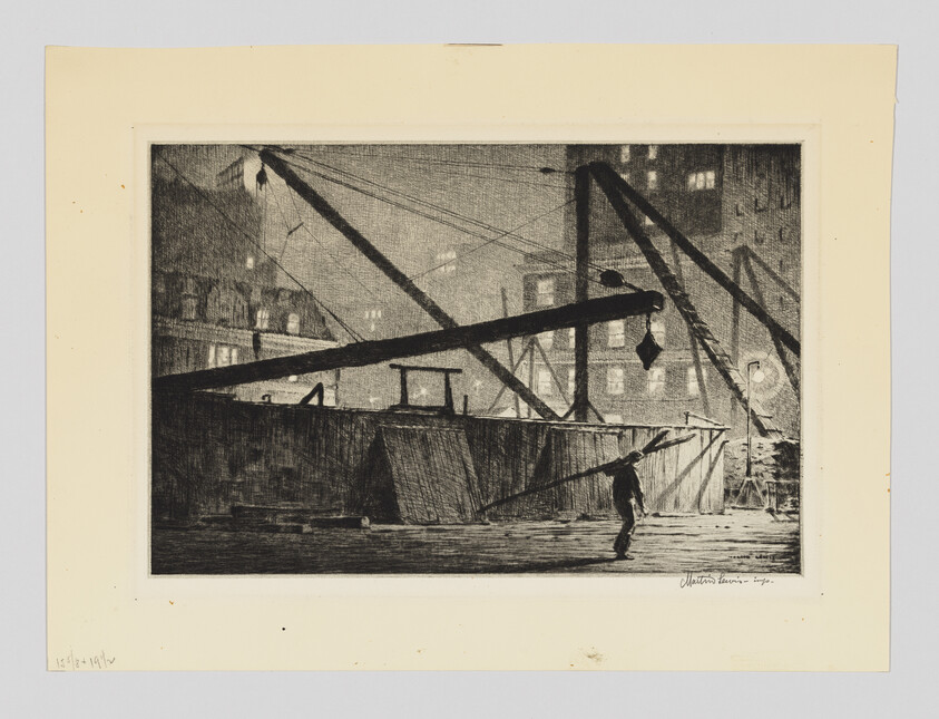 A lone worker walks near large construction cranes and beams on a dimly lit urban waterfront at night.