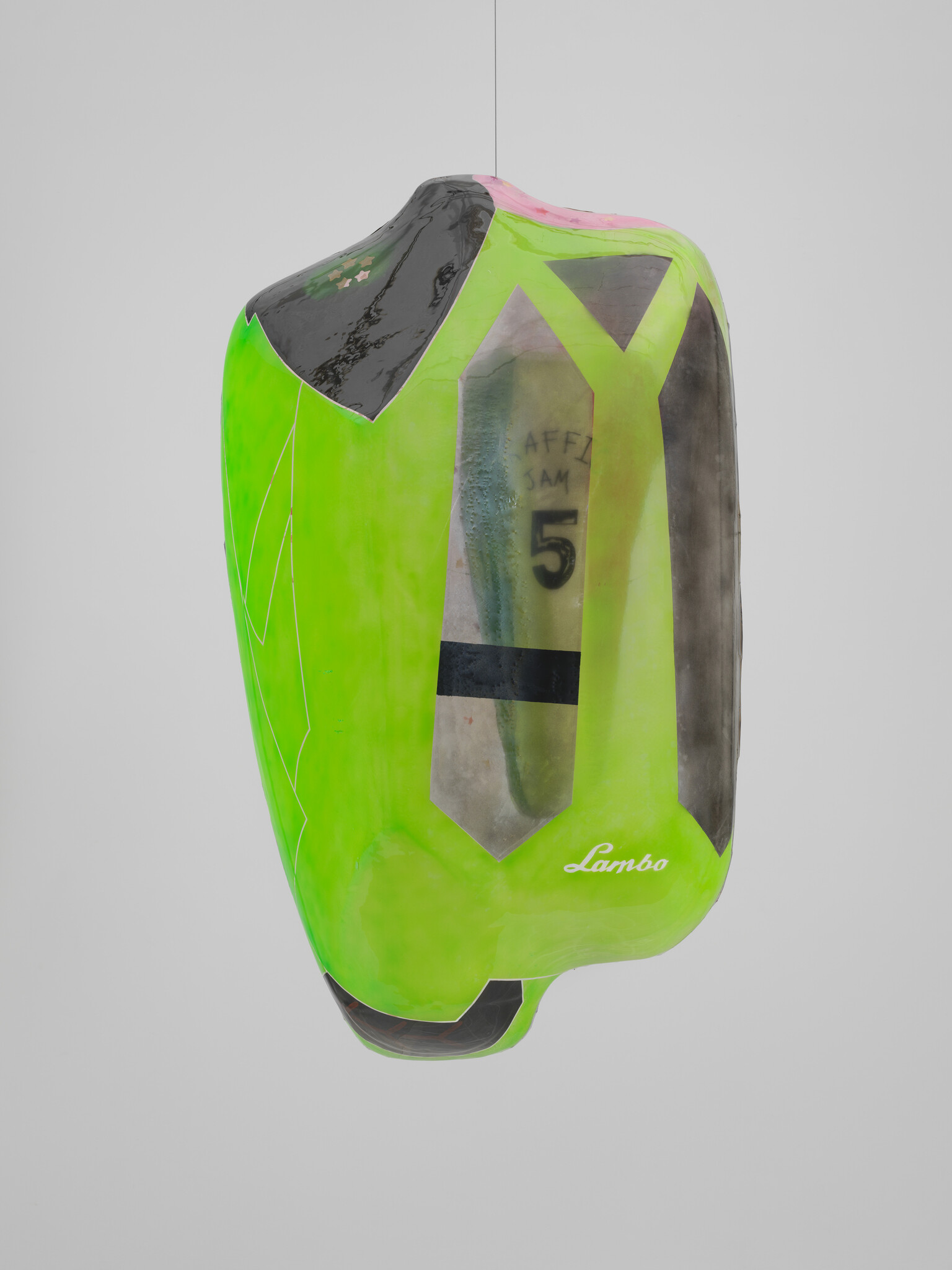 A suspended, deflated sculpture resembling a distorted, neon green sports car with visible text and number "5" on its side, against a white background.