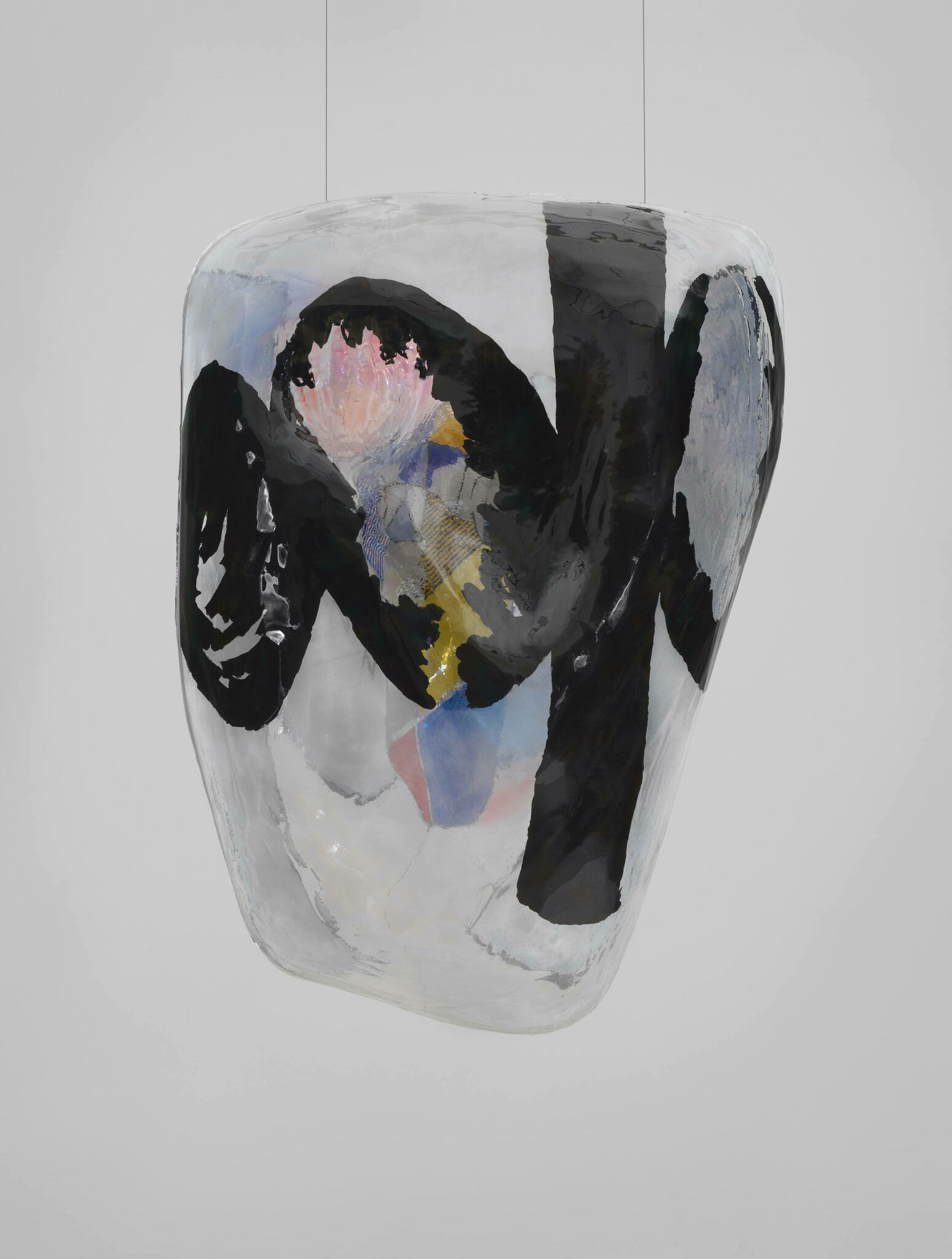 A hanging, transparent blob with bold swaths of black and patches of pale colors.