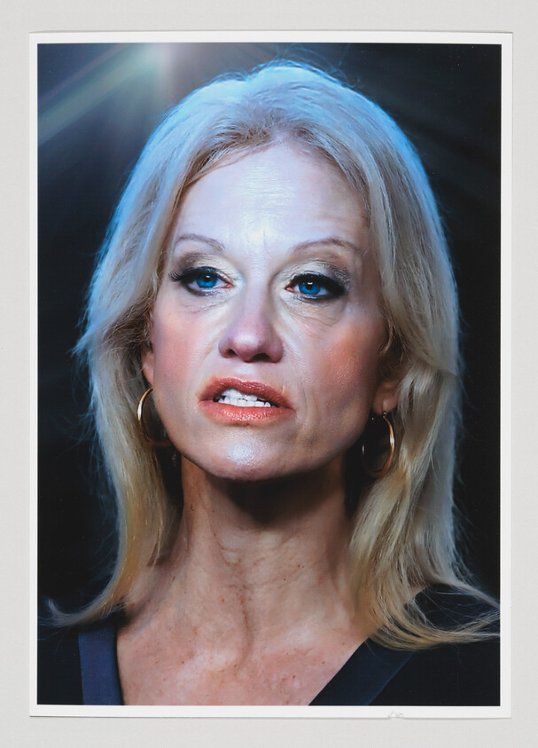 Blonde woman with hoop earrings and makeup looking slightly to her right under studio lighting.