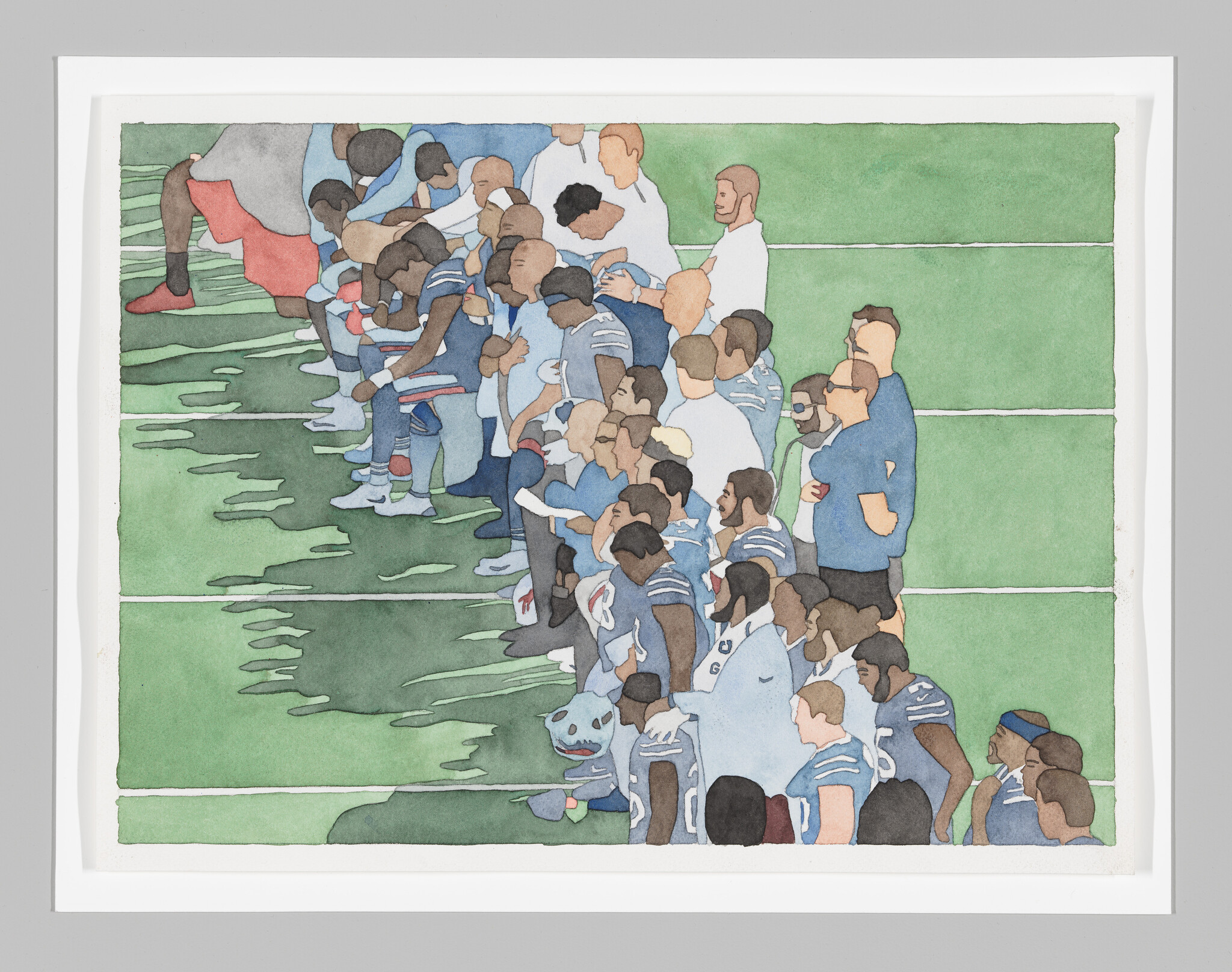 An aerial view of Black football players taking a knee and/or bowing their heads, accompanied by coaching staff.