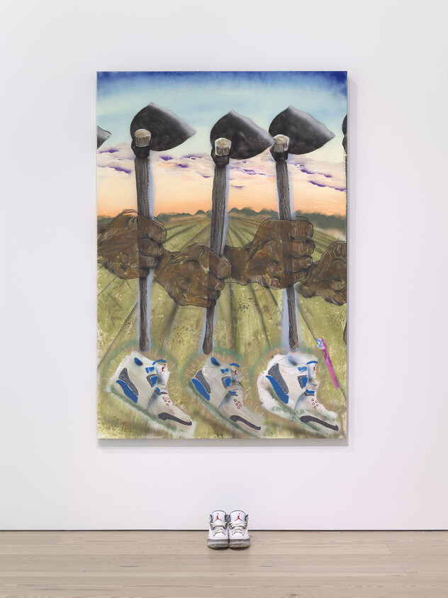 A painting shows several hands holding hoes over a field, with sneakers and a toothbrush at the bottom. A real pair of sneakers is placed on the floor below the painting.