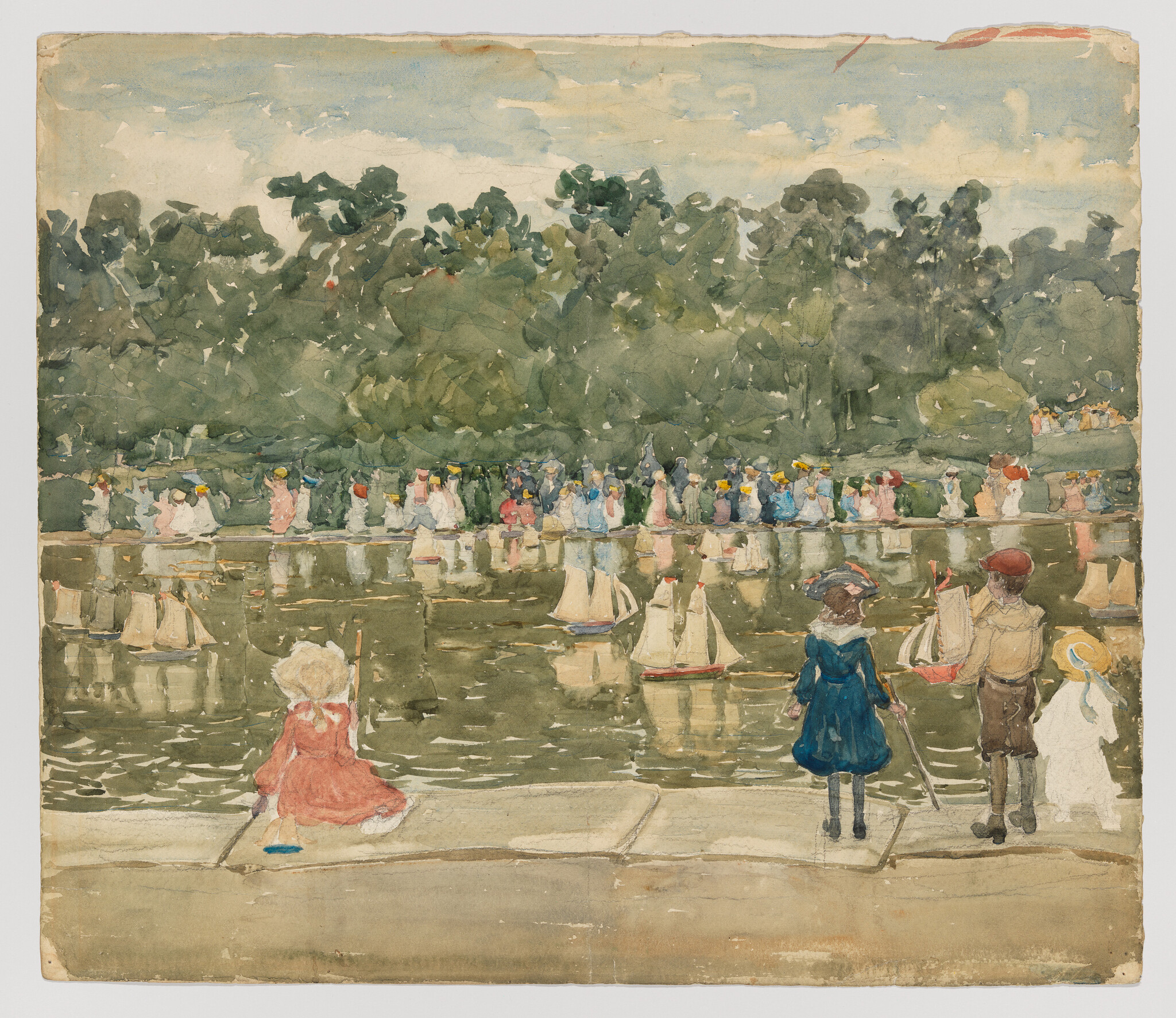 Three children watch toy sailboats on a pond while people gather along the far shore.