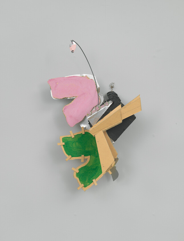 Abstract wall sculpture with pink and green painted shapes, wire, and black and beige pieces.