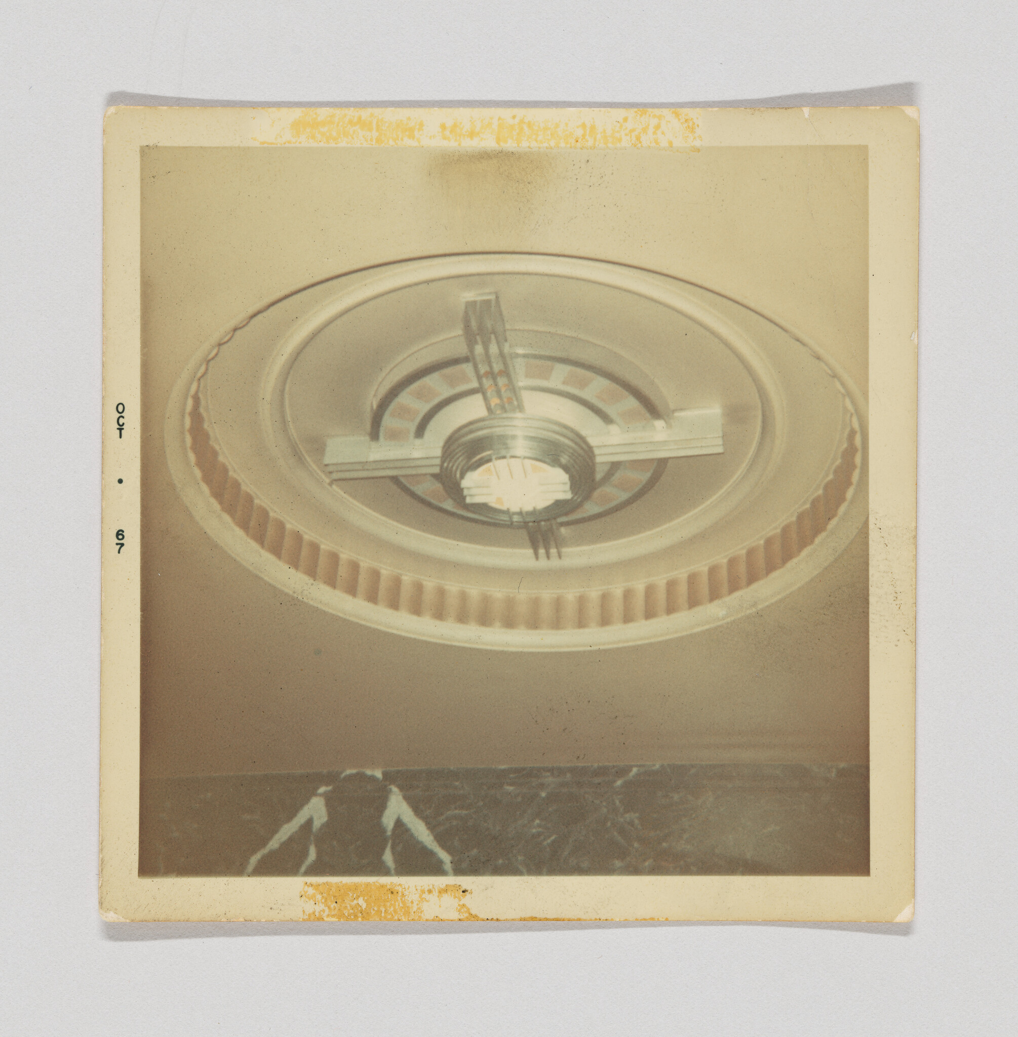 A large round decorative ceiling light with an art-deco center and a person silhouette below.