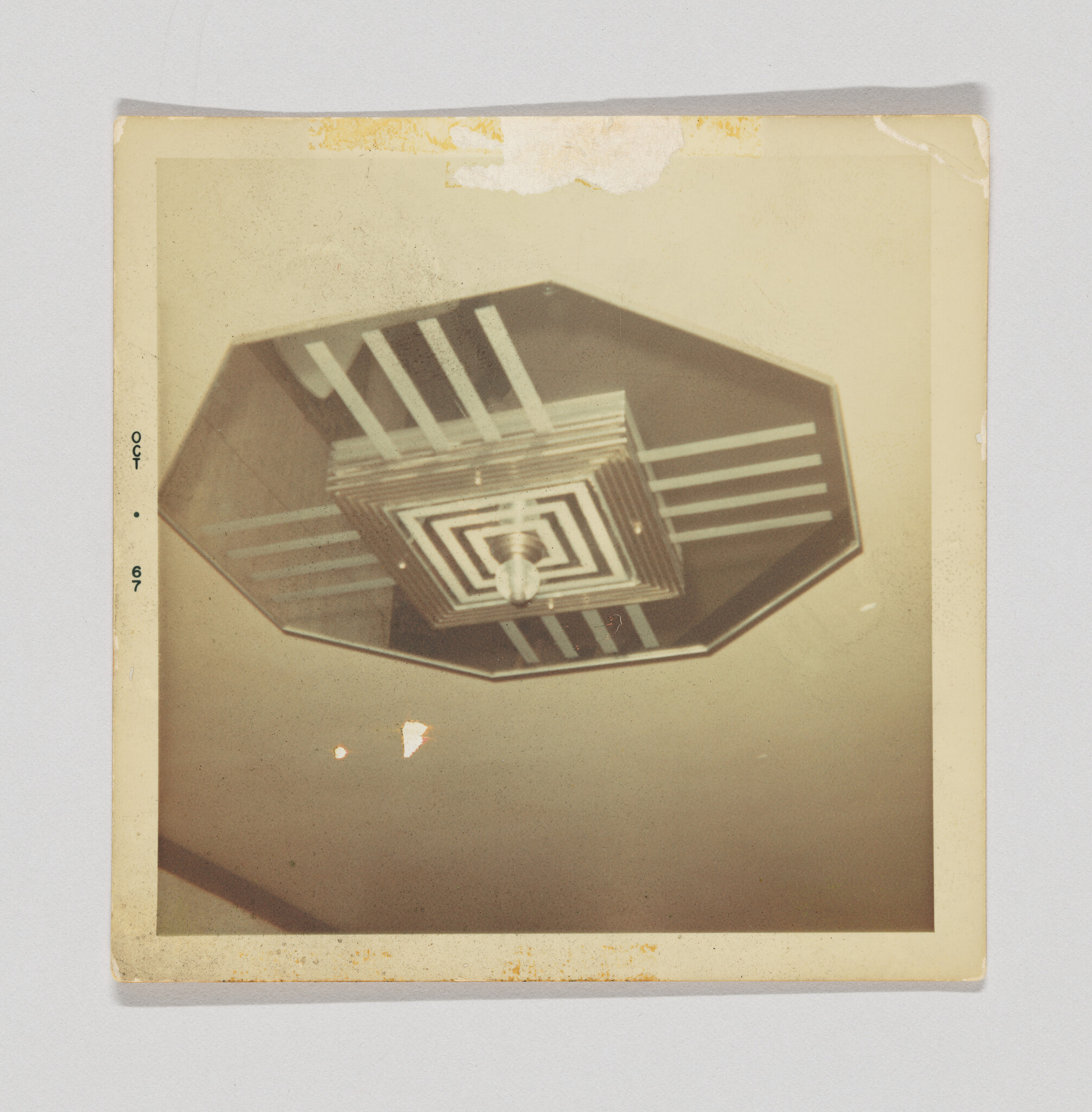 Octagonal vintage ceiling light fixture with layered geometric metal panels and a single exposed bulb.