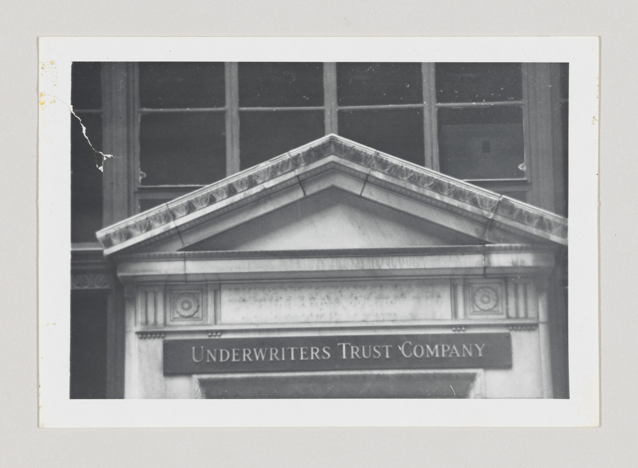 Entrance pediment of a stone building with a sign reading underwriters trust company.