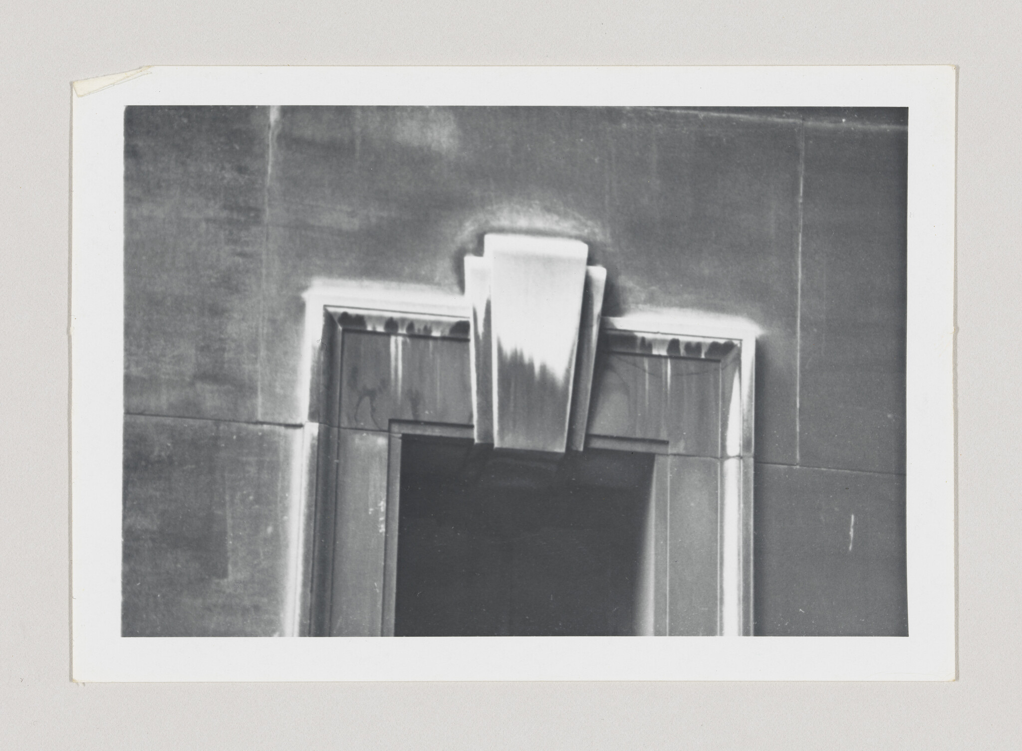 Close-up of a stone doorway with a decorative keystone and visible water stains.