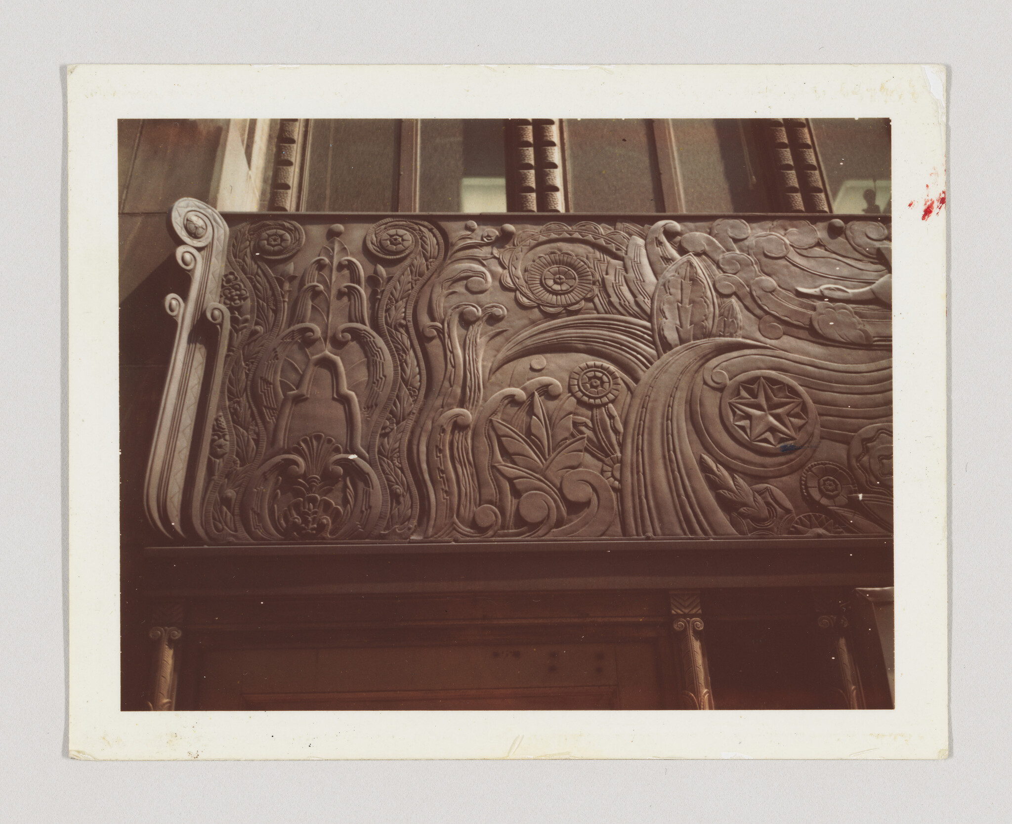 Ornate carved stone frieze with floral patterns and a star medallion above a building entrance.