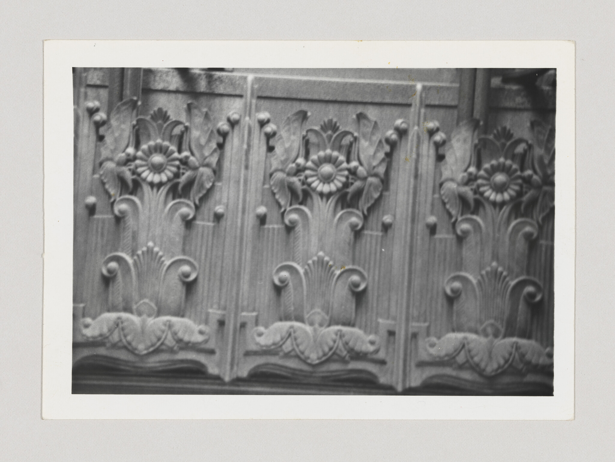 Ornate carved wooden panels with repeating floral rosettes and scrollwork along a decorative frieze.