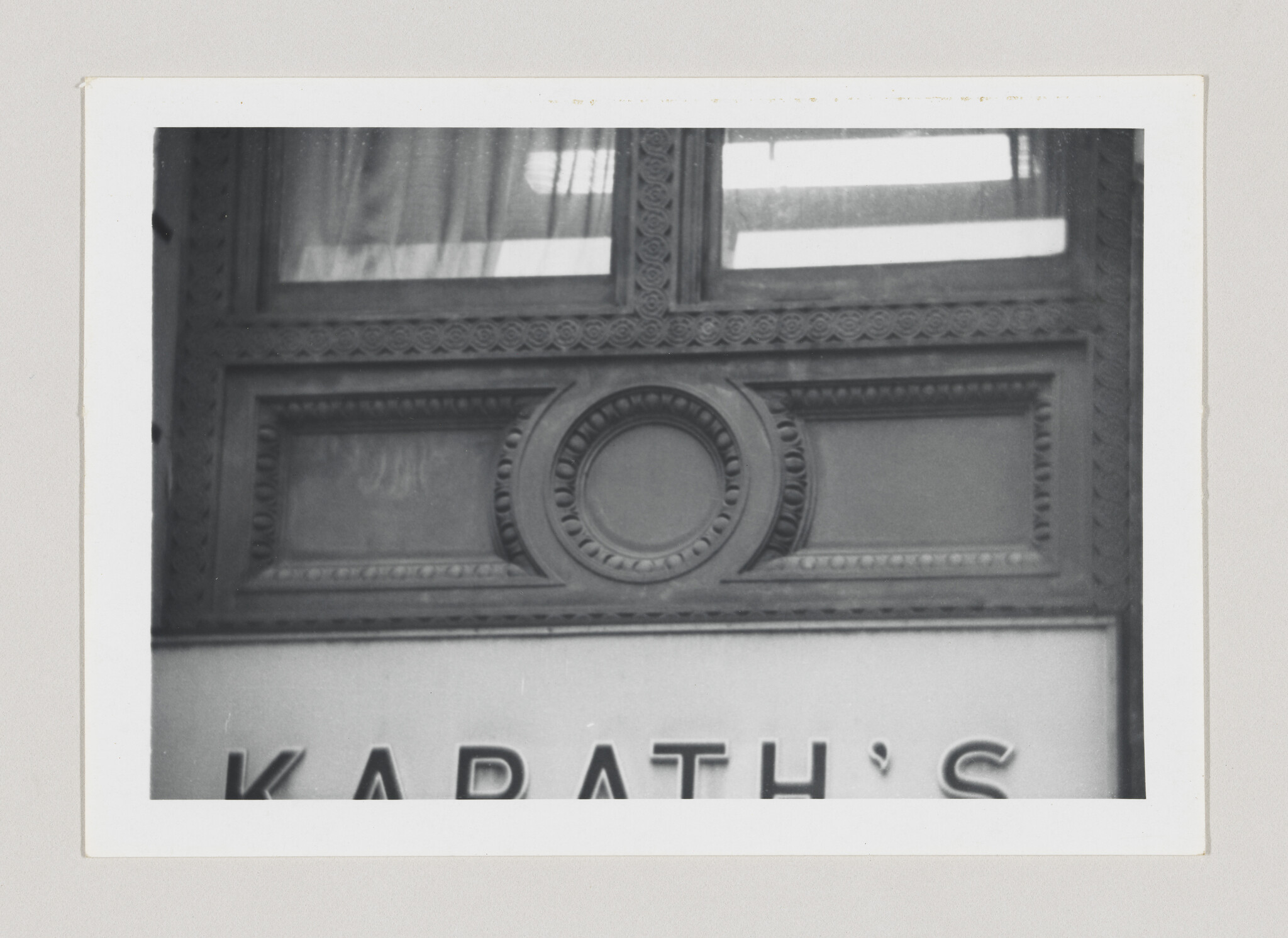 Decorative carved building facade with circular medallion above a storefront sign reading Karath's.