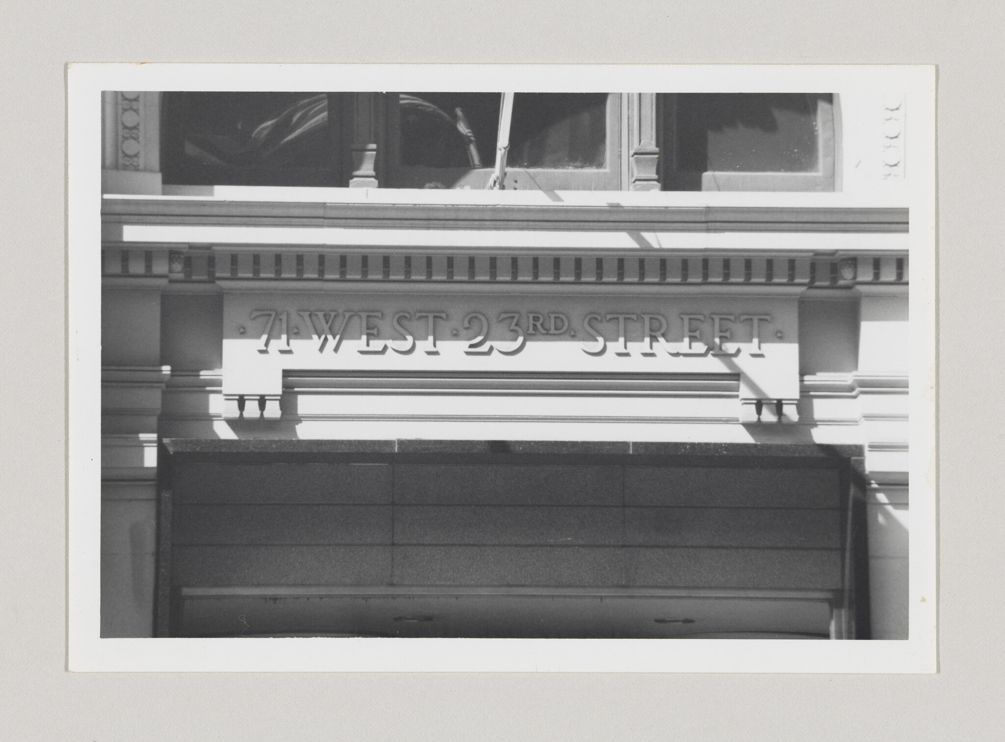 Stone building facade displaying the address 71 West 23rd Street above an entrance.