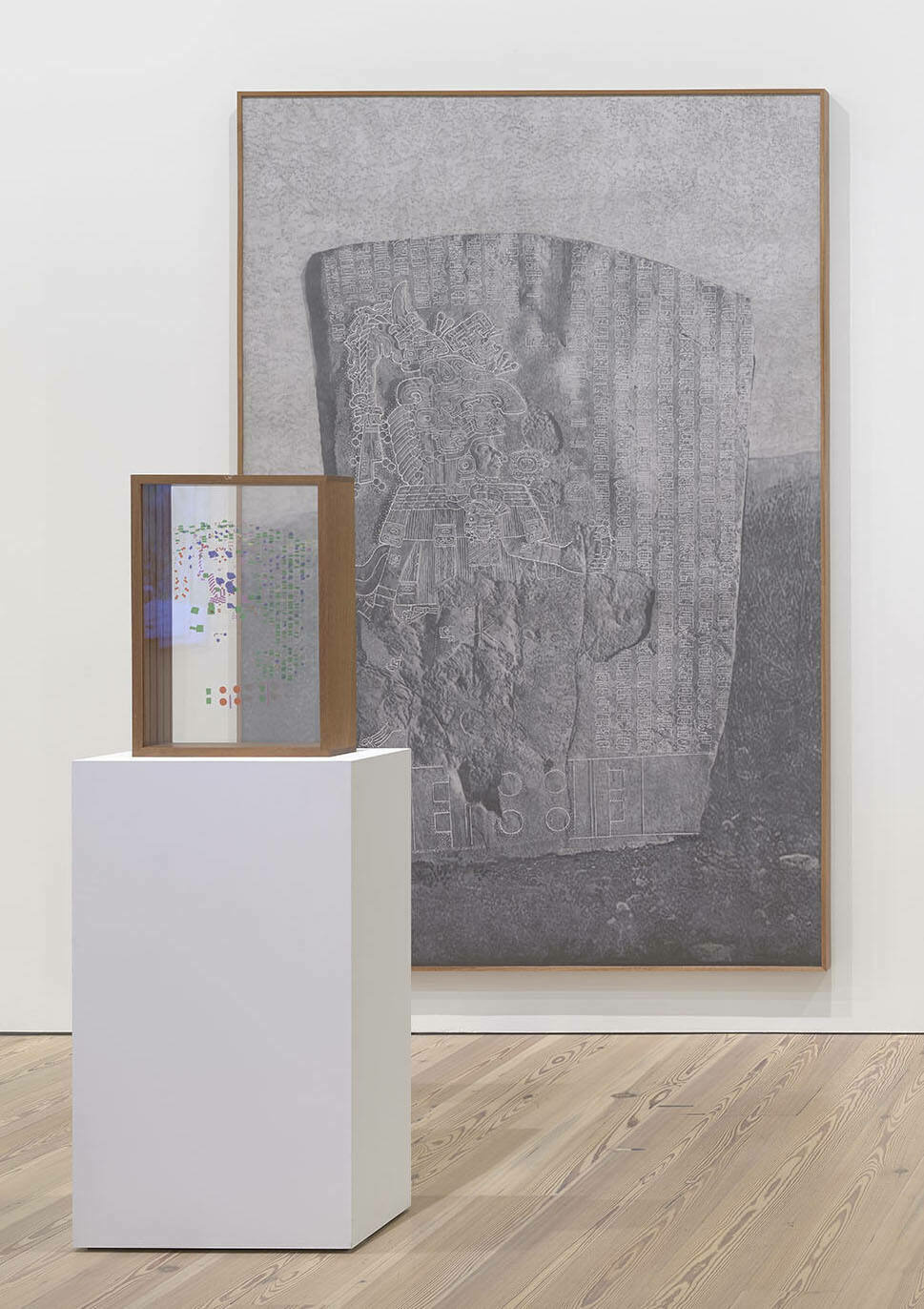 A meticulous graphite drawing of La Mojarra Stela sits behind a wooden box of plexiglass slides with colorful characters