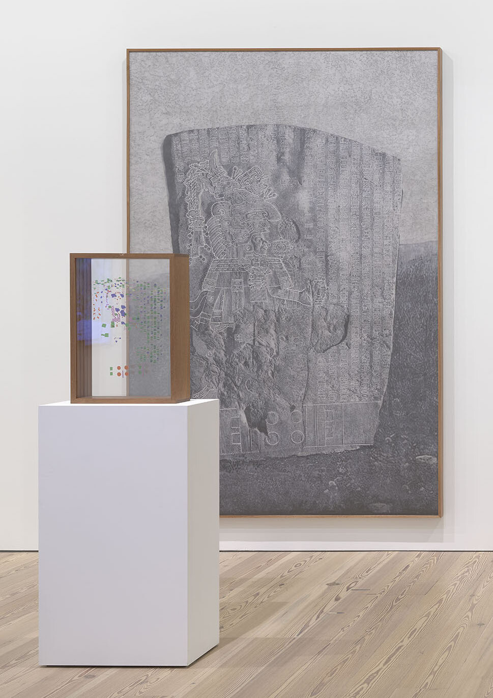 A meticulous graphite drawing of La Mojarra Stela sits behind a wooden box of plexiglass slides with colorful characters