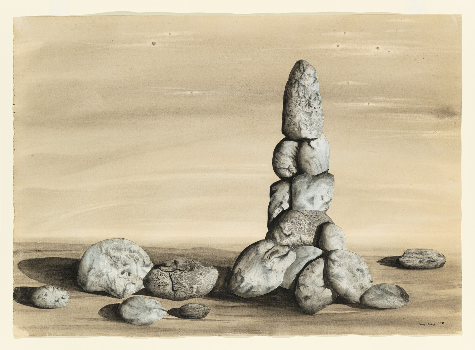 A tall stack of smooth stones rises from scattered rocks on a flat, sandy surface.