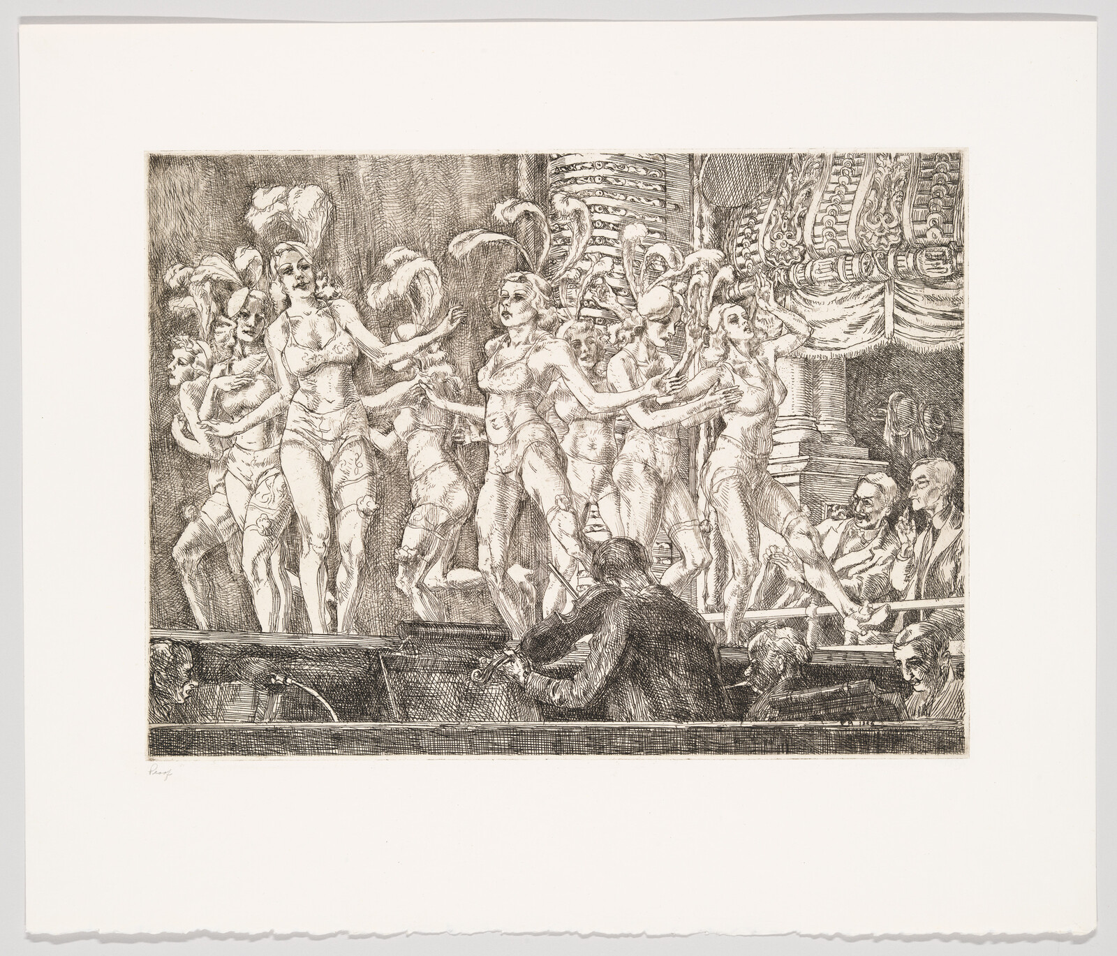 Showgirls with feathered headdresses dance on stage while an orchestra plays in the pit.