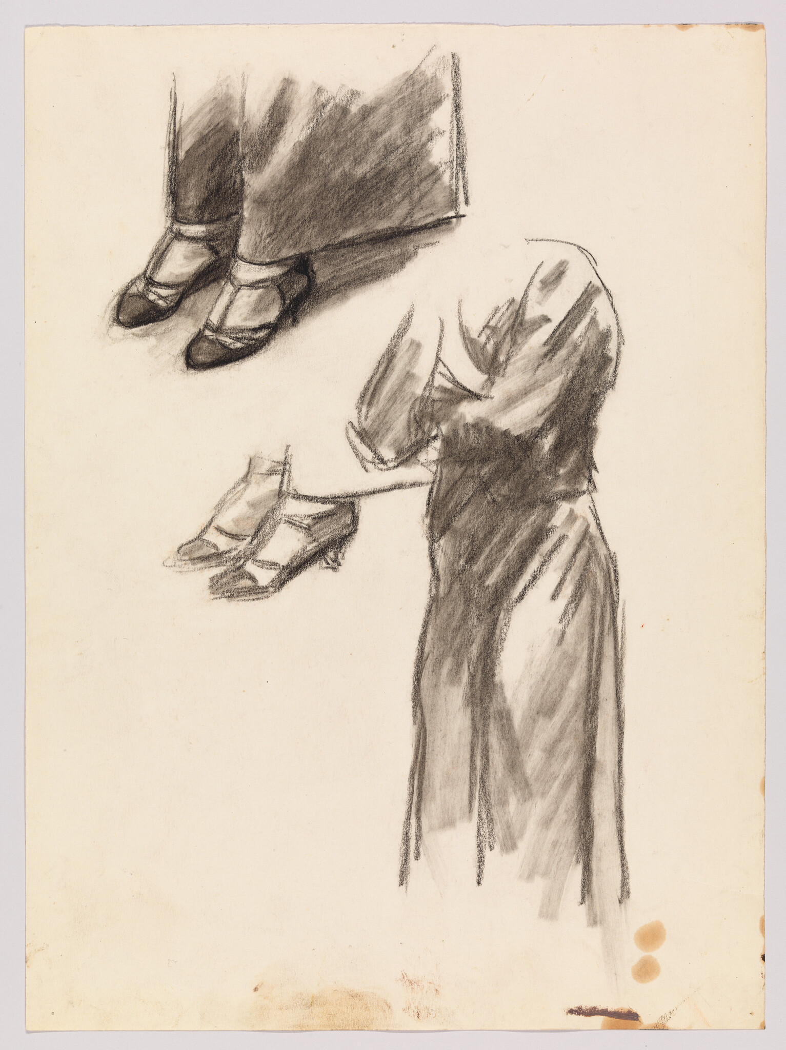 A vintage sketch on aged paper depicting two separate studies of a woman's attire. The upper part of the image shows a pair of feet in black shoes beneath the hem of a dark skirt. Below, a more detailed drawing captures a woman from the waist down, wearing a long, flowing dress and holding a pair of gloves in her left hand. The artwork is rendered in soft charcoal, with a focus on the drapery and form of the clothing. There are a few small brownish stains on the paper.