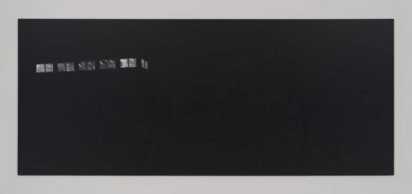 A wide black rectangular canvas with a small row of illuminated windows near the upper left corner.