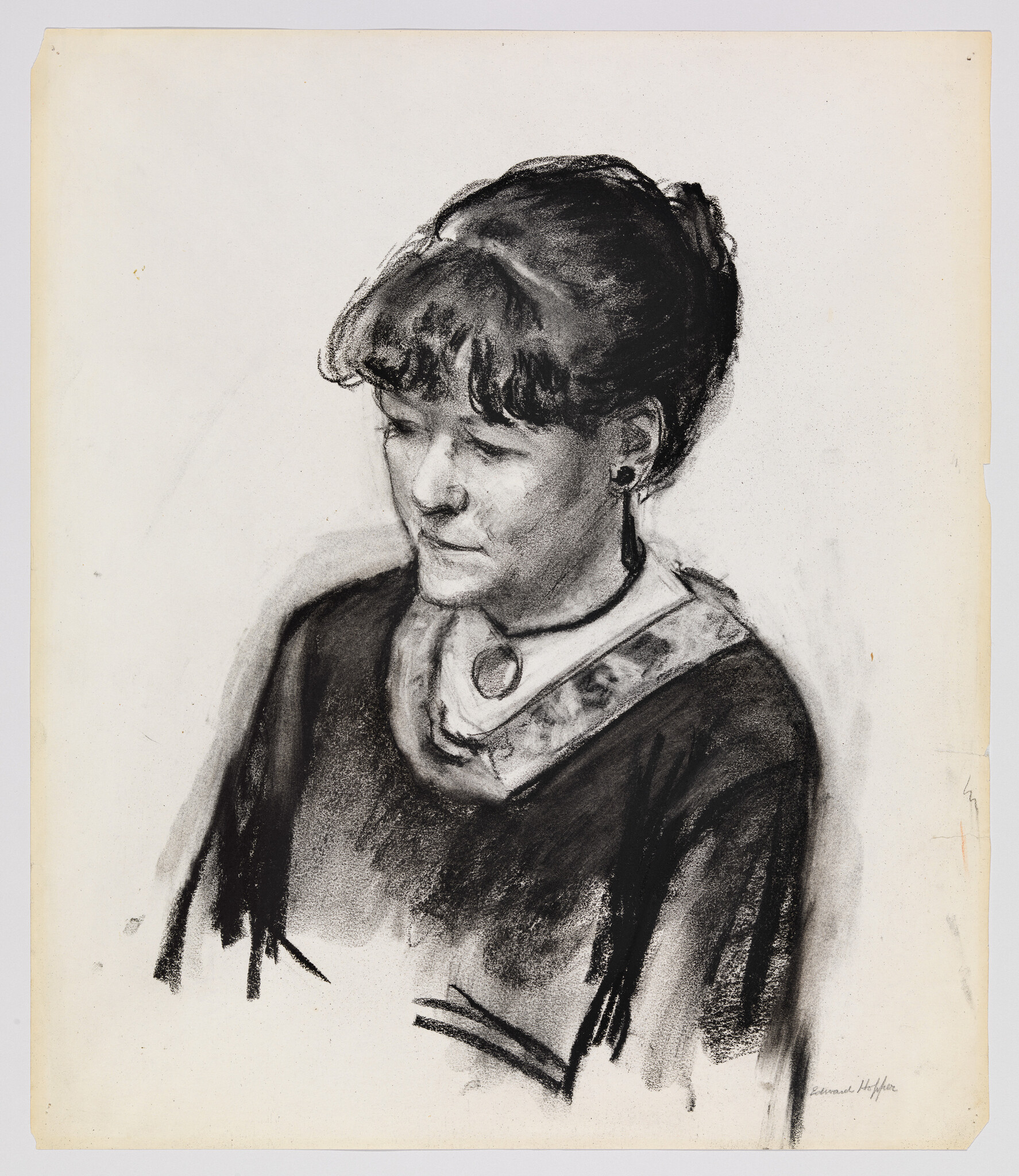 A woman with a pendant and earring looks down in a charcoal portrait.
