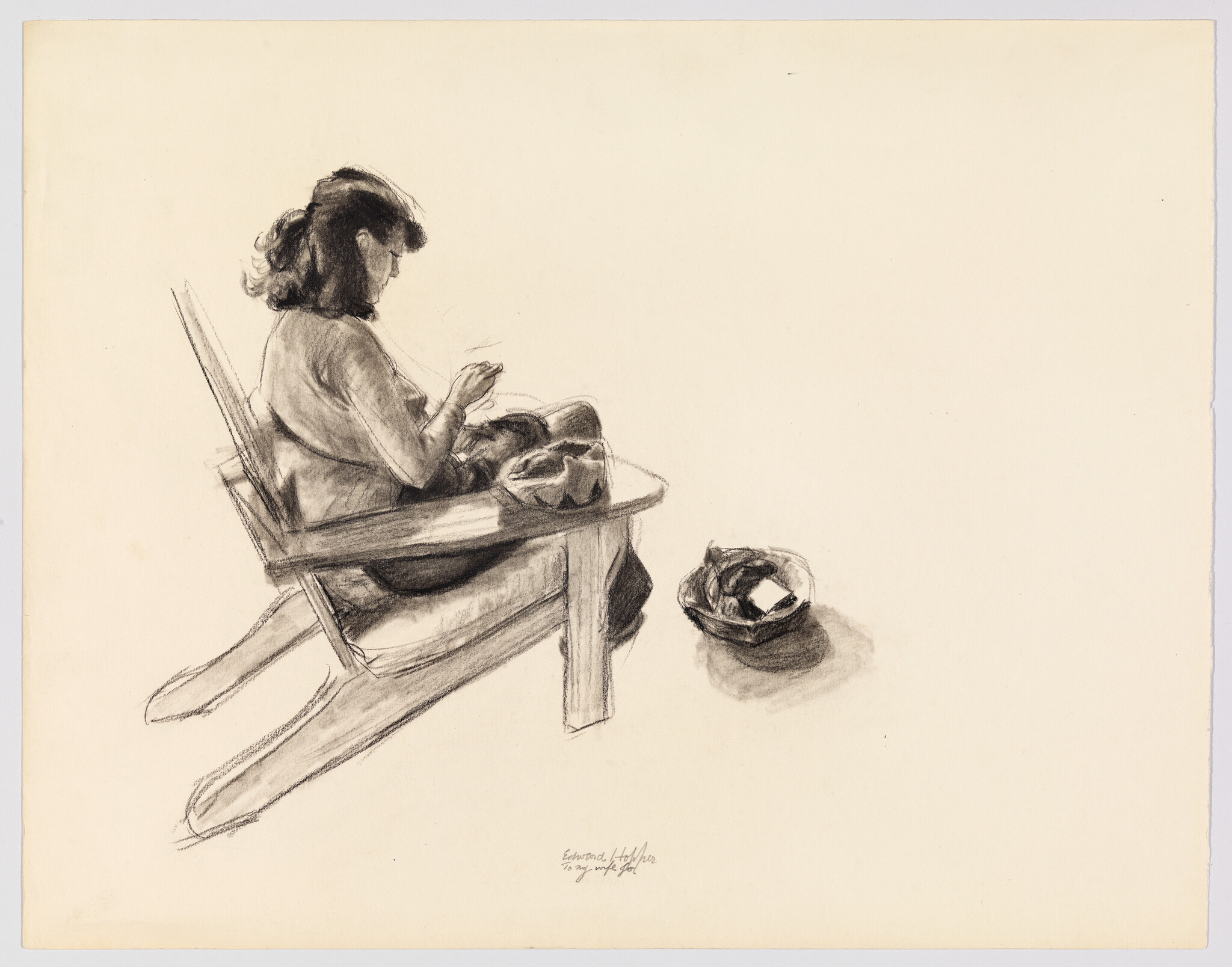 A woman sits in a wooden chair sewing with a small basket on the floor nearby.