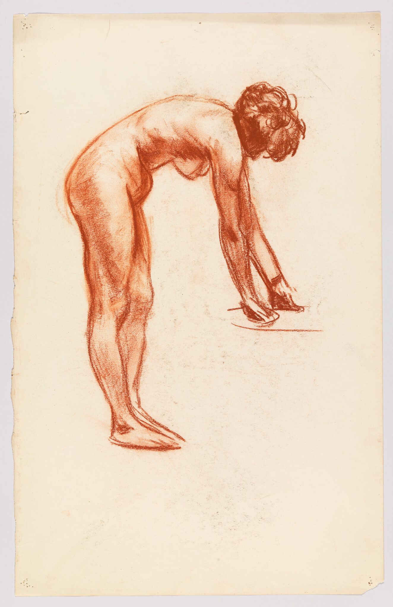 Nude woman bending forward with hands touching a surface in red chalk study.
