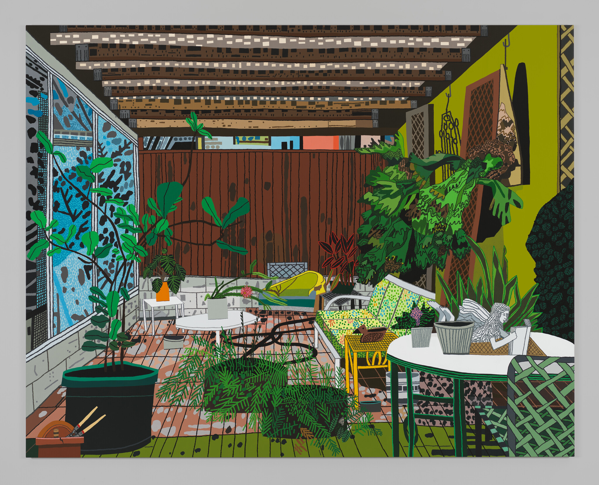 A cluttered, leisurely room with low seating and an array of potted plants