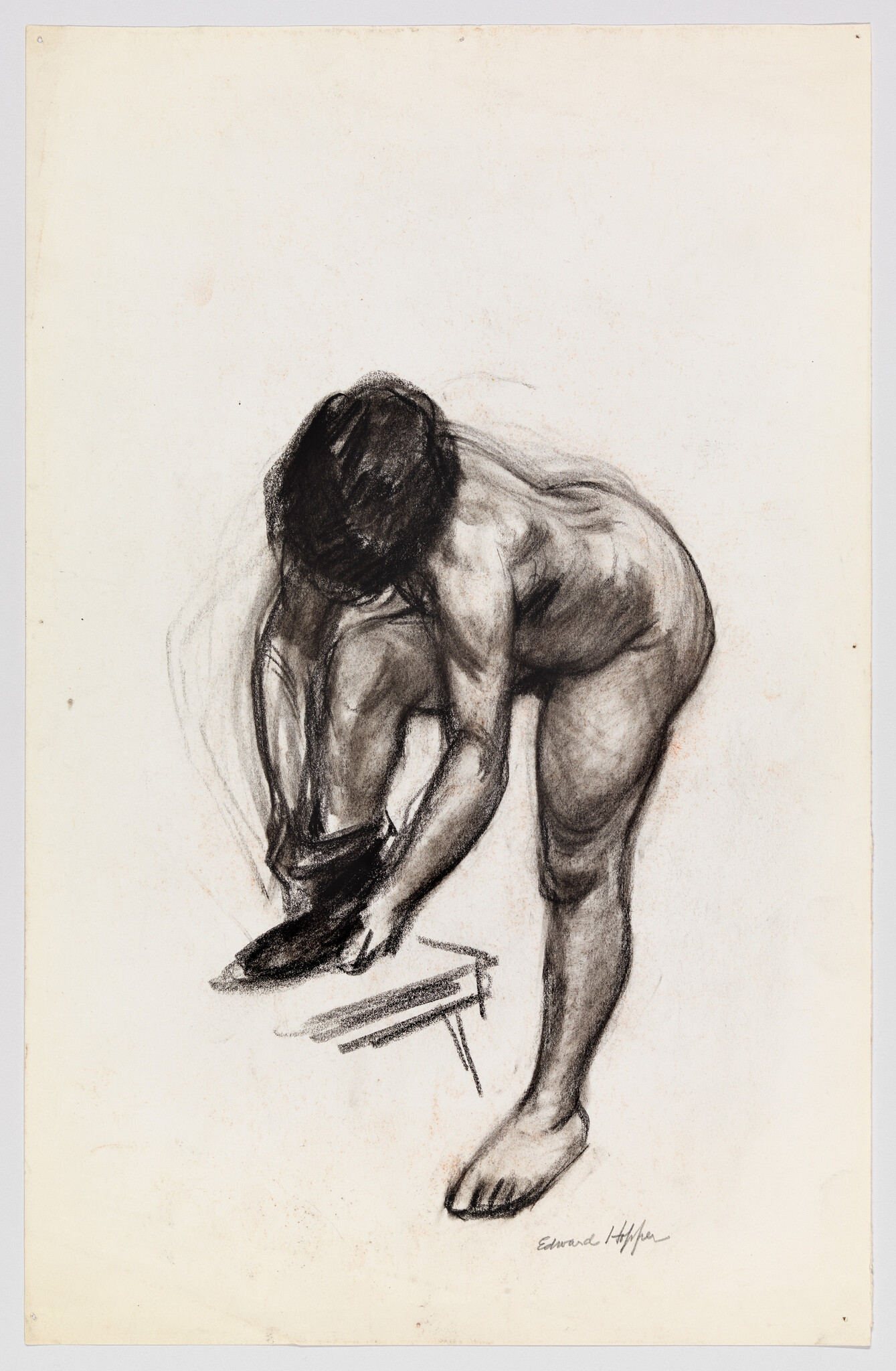 Nude woman leaning forward to put on a shoe with foot resting on a small stool.