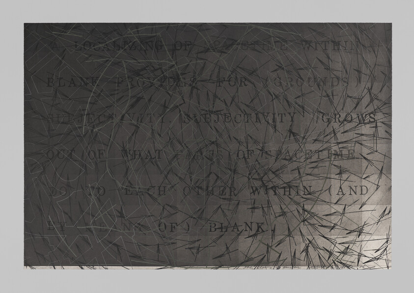 Dark panel covered in radiating scratches with faint stamped text visible across the surface.