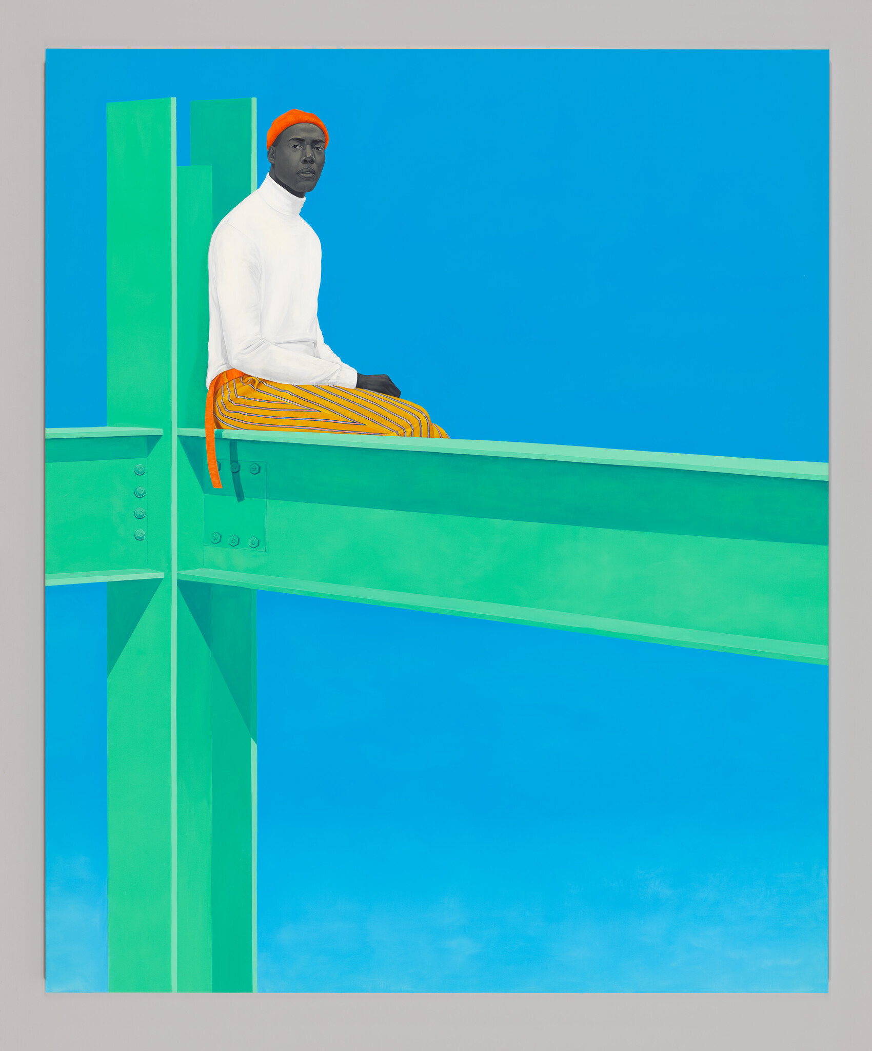 A man on the intersection of three 'I'-shaped, steel beams wearing a white turtleneck, orange beanie, and pin-striped pants.