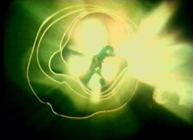 Silhouetted figure reaching toward a bright green light surrounded by concentric glowing rings.