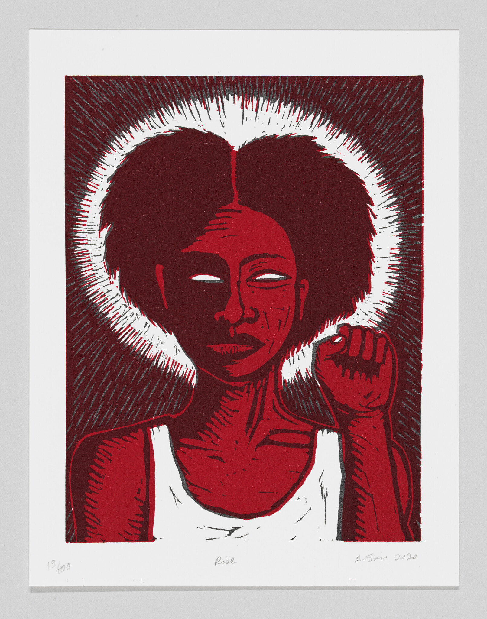 A monochrome red print of a black woman with her left fist up and a white halo.