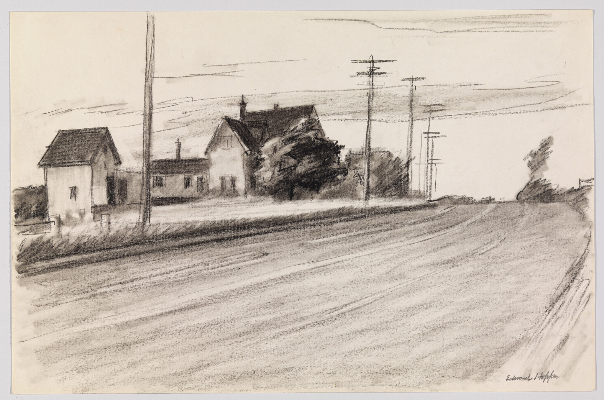 Two farmhouse buildings and trees beside a quiet road with telephone poles.