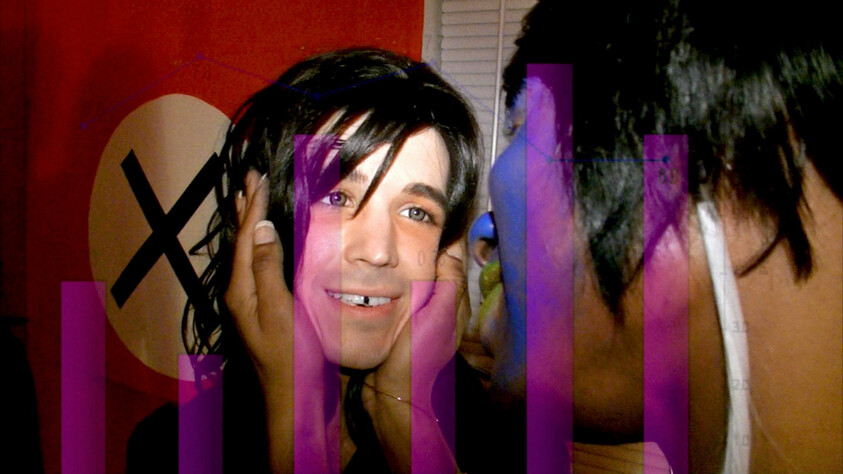 Young person smiling while another person cups their face and leans in close.