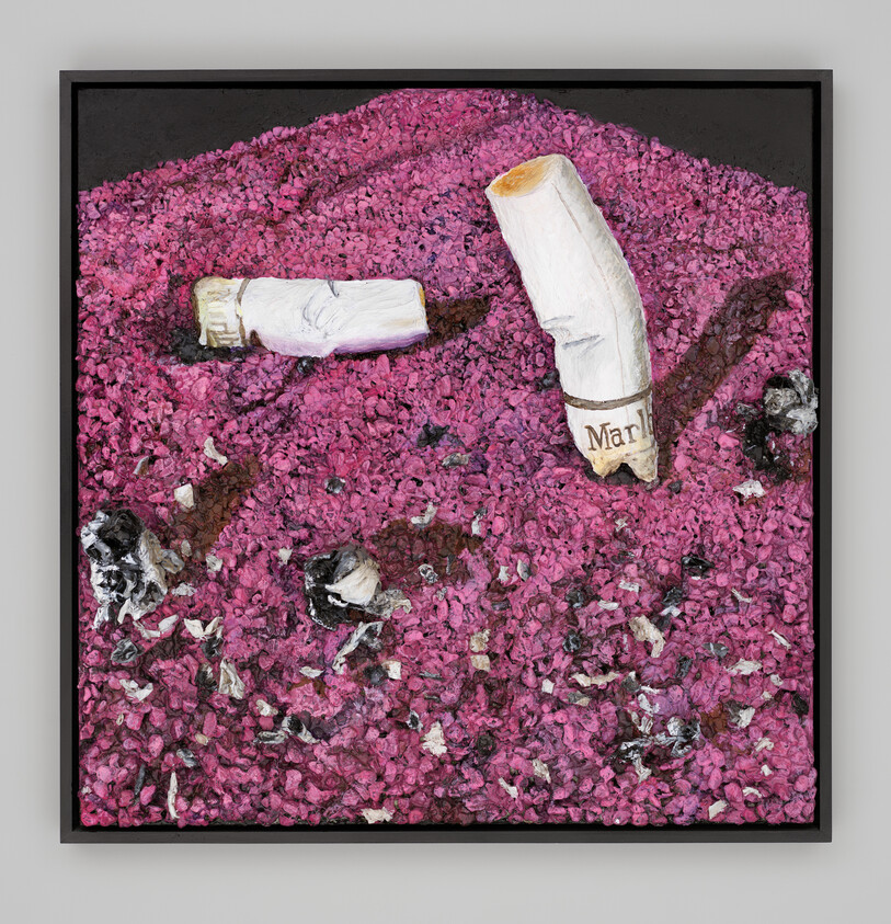 Close-up of two Marlboro cigarette butts plunged into pink ash