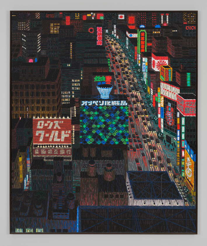 A bustling city street at night with neon signs and steady streams of car traffic.