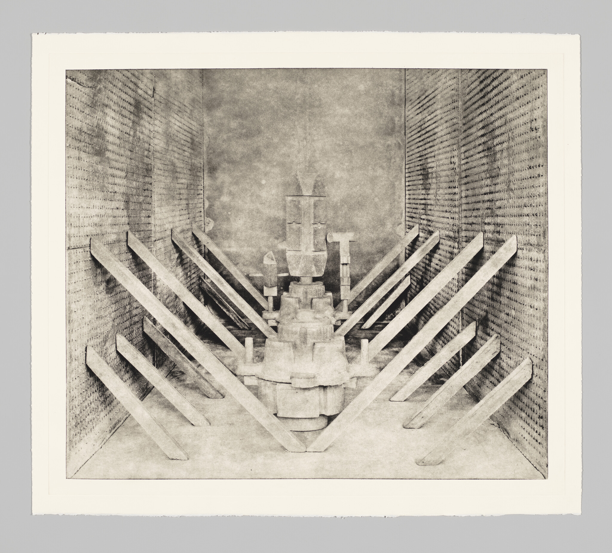 A symmetrical room with a central mechanical column and angled wooden beams leaning toward it.