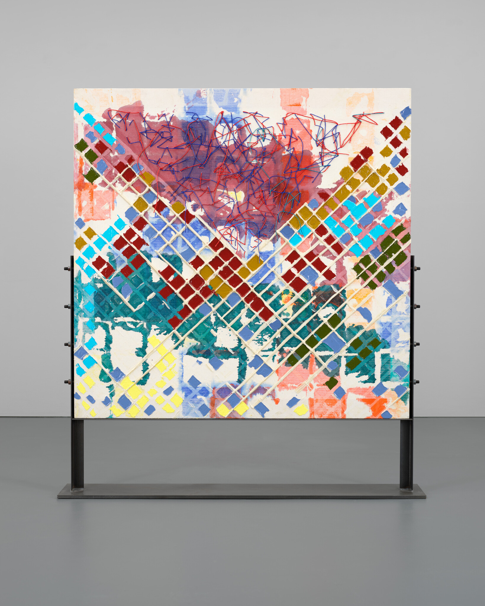 Large colorful abstract painting on a metal stand featuring diamond grid pattern and red scribbles.
