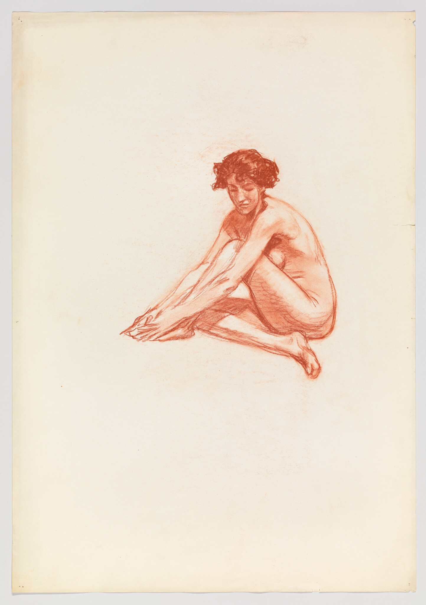 A red chalk drawing of a seated nude woman bending forward to touch her toes.