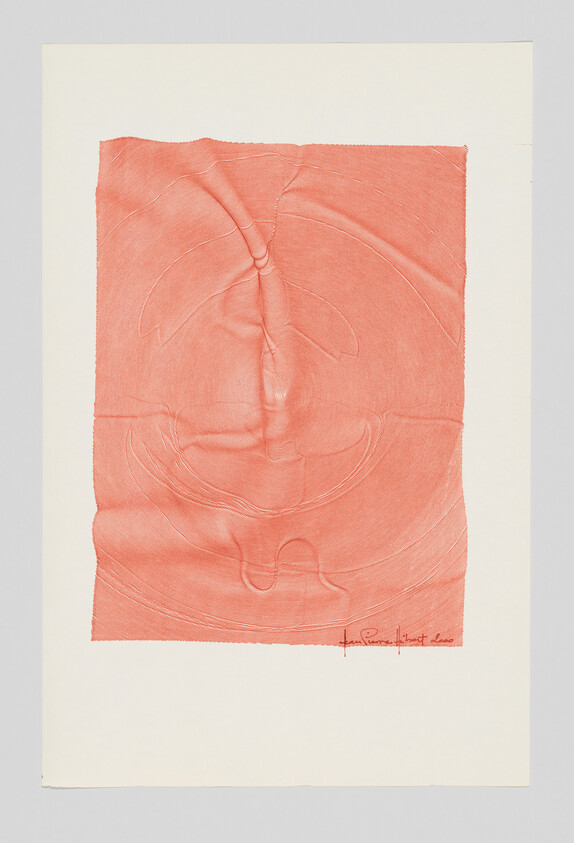A coral-colored embossed paper with circular impressions and a small handwritten signature at the bottom right.