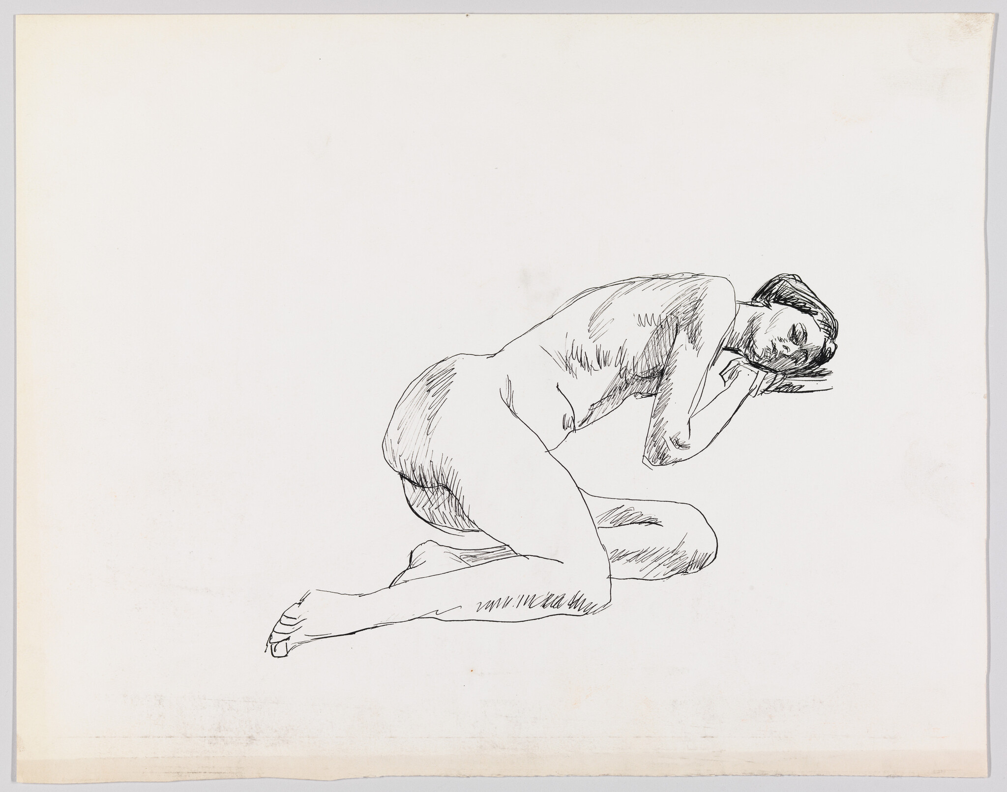 A nude woman kneels on the floor resting her head on folded arms.