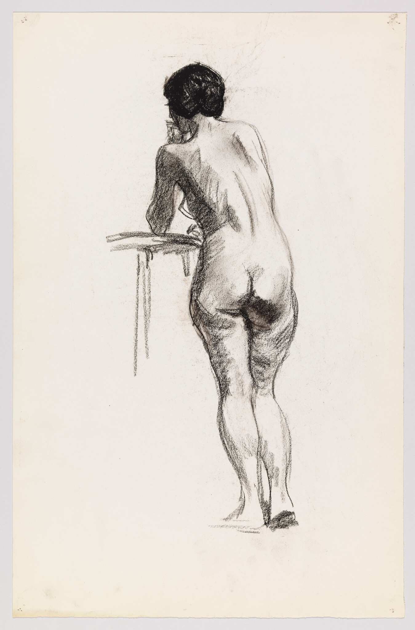 Nude woman leaning on a low table, viewed from behind in a charcoal sketch.