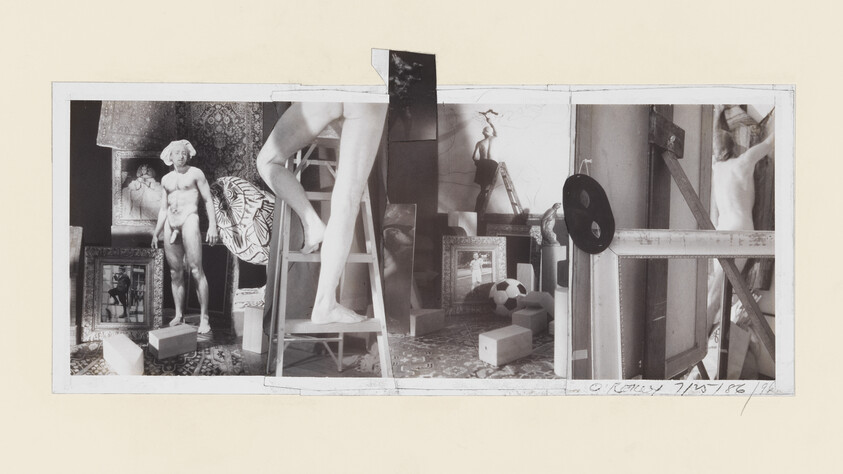 A cluttered artist's studio with classical male plaster statues, a ladder, framed pictures, and scattered props.