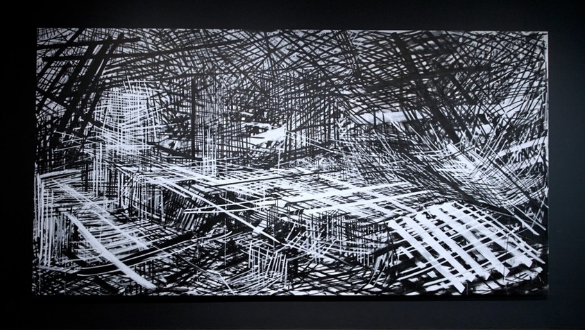 Harsh black and white lines fill the canvas forming box-like shapes and a hectic, claustrophobic atmosphere.