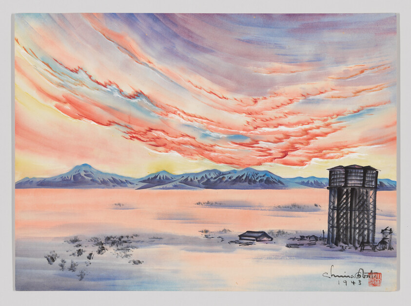 Two tall silos stand beside small buildings on a snowy plain under a colorful sunrise.