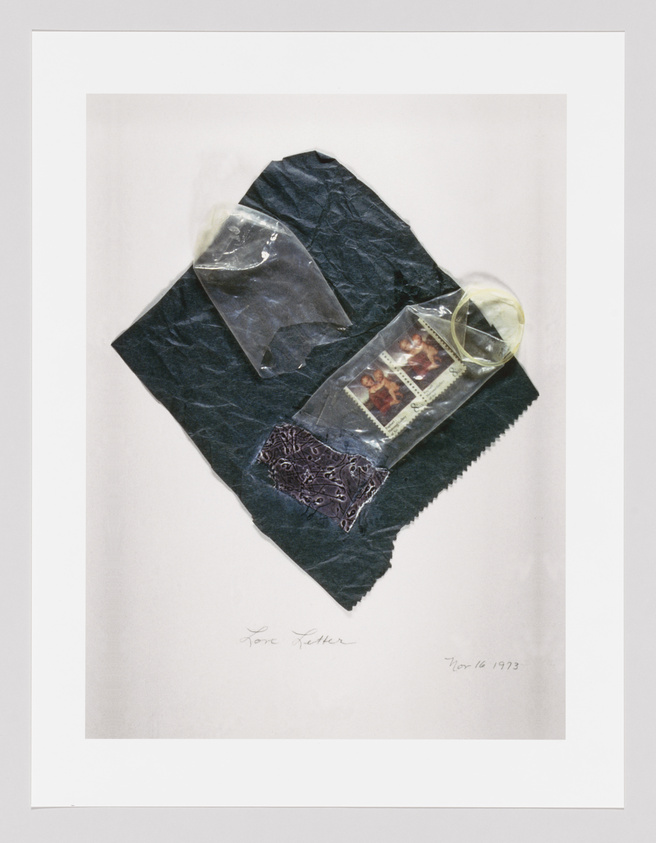 Artwork featuring dark fabric with transparent pockets containing photographs, signed and dated by the artist.